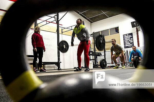 Female lifting weights under the supervision of the coach