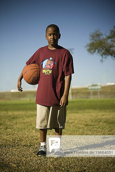 MIAMI  FLORIDA. Terrance Penn stands for an environmental portrait outside the Overtown Youth Center. MIAMI  FLORIDA. Terrance Penn holds a basketball on the gymnasium floor of the
