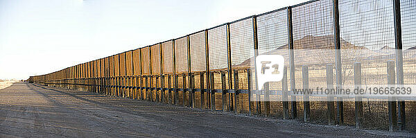 A pedestrian-style fence runs along the Mexican border in Arizona.