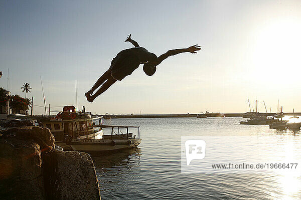 Boy jumps to the water at the old port  Salvador  Bahia  Brazil.