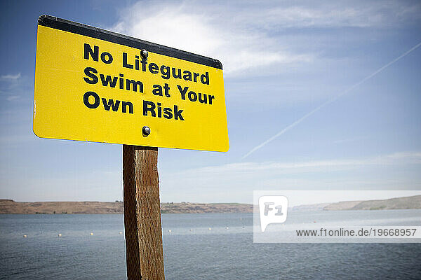 No Lifeguard Swim at Your Own Risk sign posted at a swimming area along the Columbia River Gorge in Oregon.