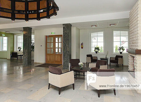 Modern building interior  hotel  reception area  pillars and tiled floor  fireplace and atrium.