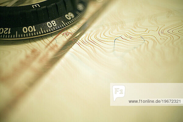 Detail view of a compass on a topographic map  used for planning backpacking and hiking trips.