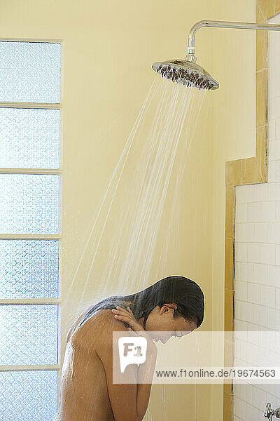 A young woman taking a shower.