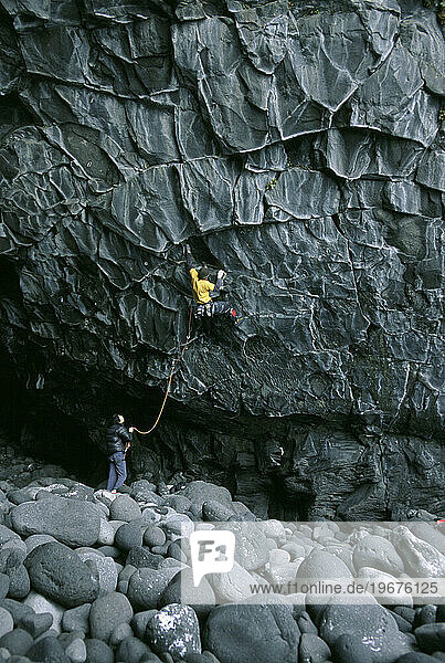 A man climbs artistic rock.