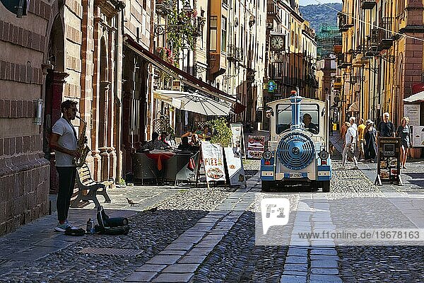 Bimmelbahn  Straßenmusiker  Fußgänger und Touristen in der malerischen Altstadt von Bosa  Oristano  Westsardinien  Sardinien  Italien  Europa