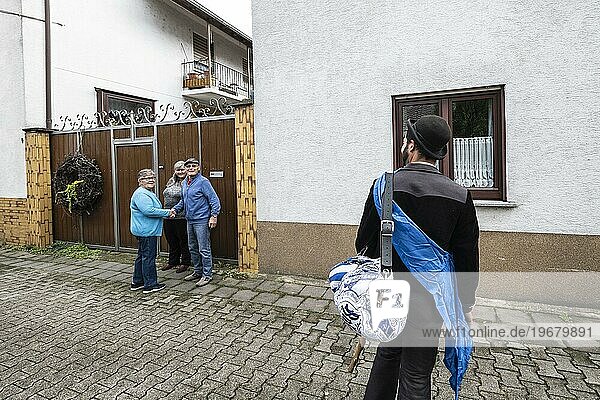 Einheimischmeldung eines Rolandsbruders nach Beendigung seiner Walz  er wird von Freunden vom Ortschild zu seinem Elternhaus begleitet und von Nachbarn begrüßt  Großniedesheim  Deutschland  Europa