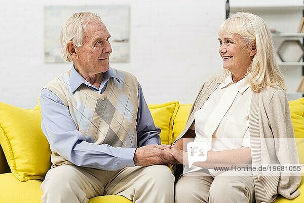 Alter Mann Frau spricht gelbes Sofa