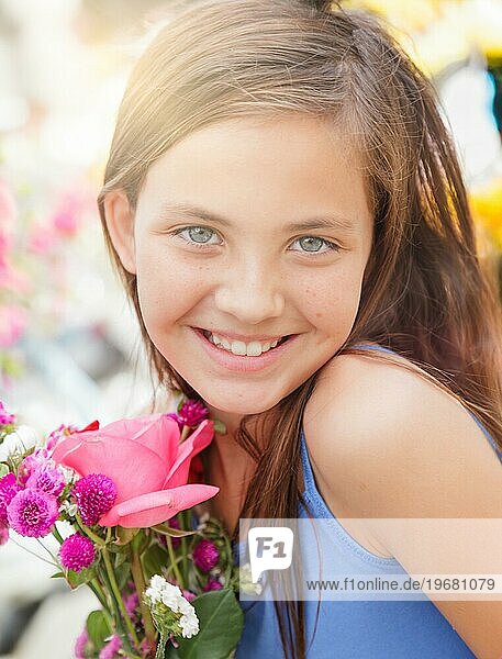 Bezauberndes  glückliches  junges  blauäugiges Mädchen  das einen frisch geschnittenen Blumenstrauß auf dem Bauernmarkt hält