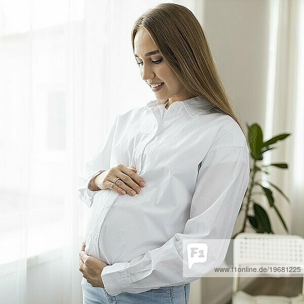 Seitenansicht schwangere Geschäftsfrau hält ihren Bauch