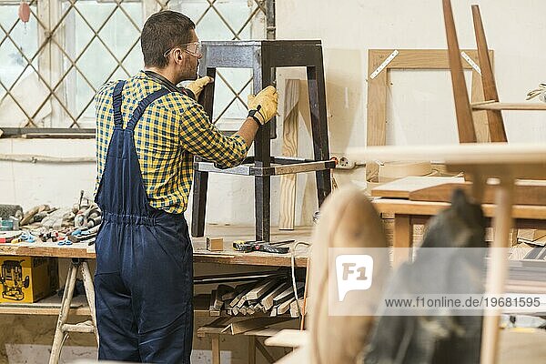 Seitenansicht männlicher Schreiner bei der Herstellung von Holzmöbeln Werkstatt