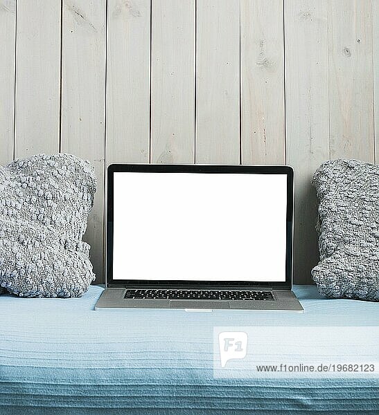 Laptop mit leeren weißen Bildschirm Kissen Sofa