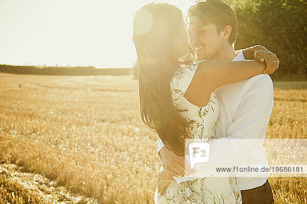 Smiling Couple Hugging in a Field
