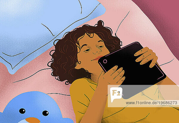 View from above happy girl laying  using digital tablet on bed at home