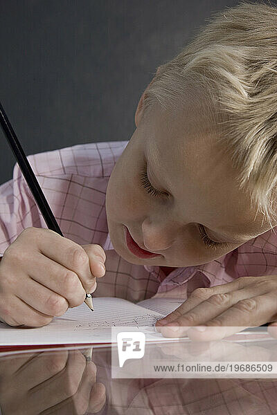 Boy sitting at desk writing