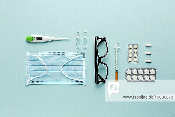 Spectacles pills laptop near stethoscope blue surface