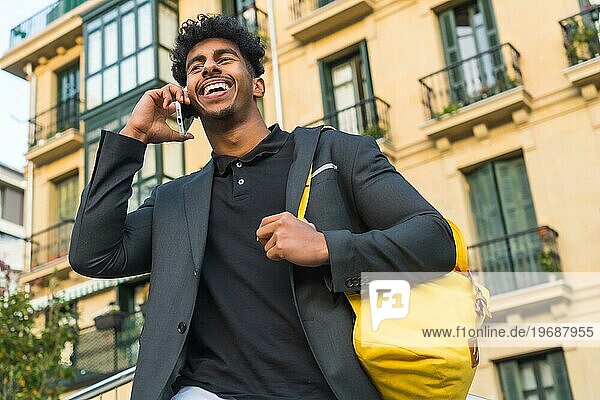 Low Winkel Ansicht Porträt der lässigen arabischen Geschäftsmann im Gespräch mit dem Telefon im Freien