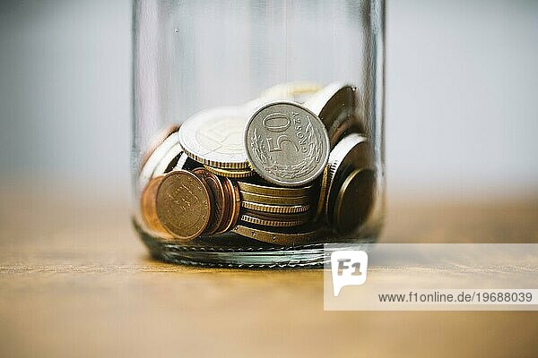 Nahaufnahme gesammelte Münzen Glasgefäß Tisch