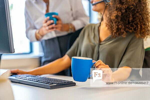 Fokus auf einen Kaffeebecher in den Händen einer Frau in einem Coworking