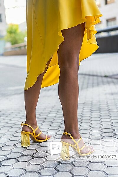 Vertikale beschnitten Foto der sinnlichen Beine einer Frau tragen gelbe Kleid Fersen