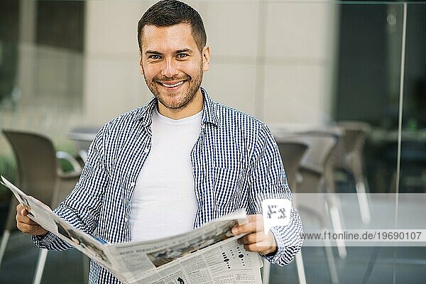 Hübscher Mann liest Zeitung im Café