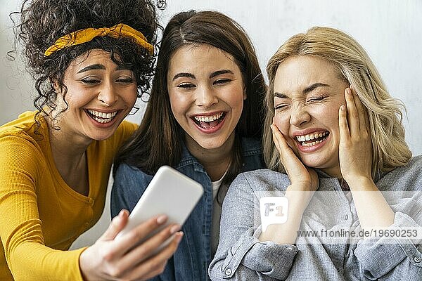 Frontansicht drei glückliche Frauen lächelnd unter selfie
