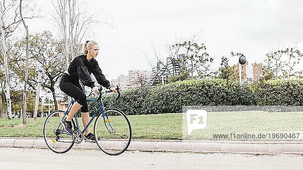 Lovely woman riding bicycle park