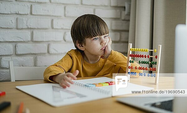 Vorderansicht Kind mit Abakus beim Lernen am Laptop zu Hause