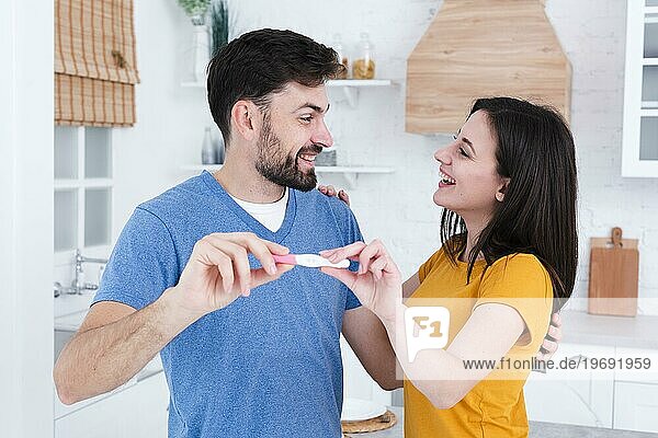 Glückliches Paar zeigt den Schwangerschaftstest