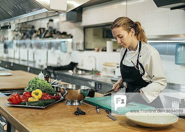 Seitenansicht weibliche Köchin Küche schneidet Gemüse