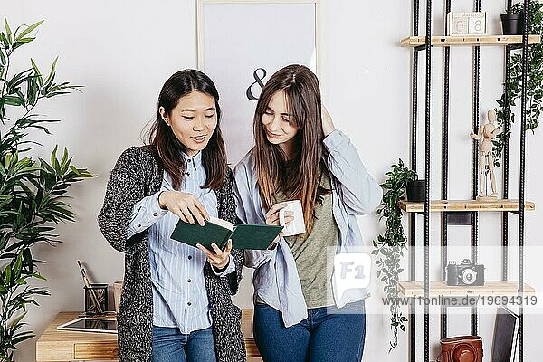 Zufriedene Mädchen lesen gemeinsam ein Buch