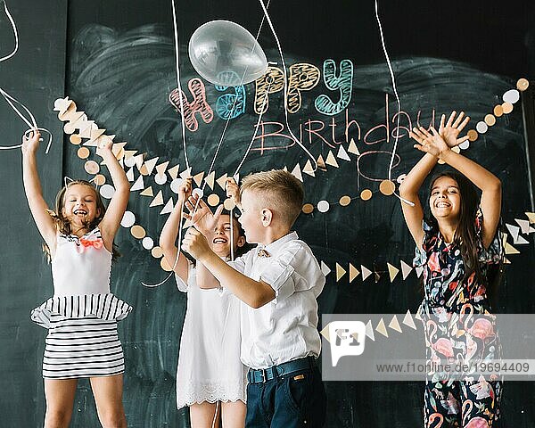 Fröhliche Kinder lassen Luftballons steigen Geburtstagsfeier