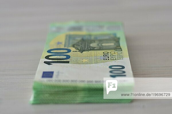 Viele einhundert Euro Scheine als Stapel auf einem Tisch  Symbolbild für Bargeld  Reichtum oder Korruption