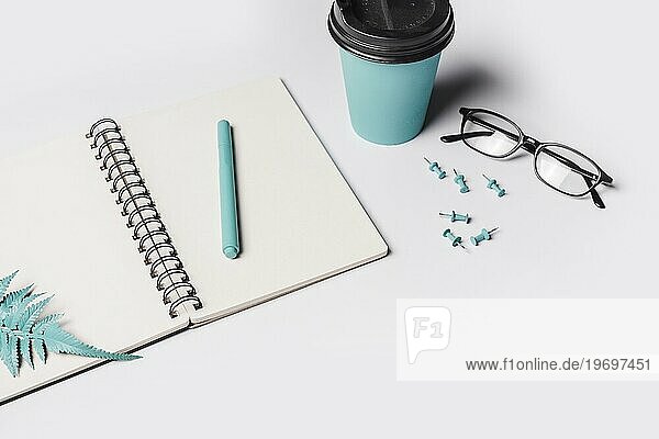 Künstlicher Farn Blätter Stift weiß leer Spirale Notizbuch mit Kaffeetasse Brille Pushpin