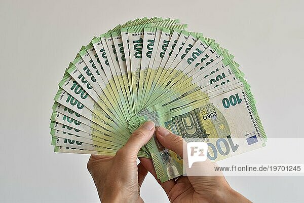 Eine Hand zählt viele einhundert Euro Geldscheine aufgefächert wie ein Fächer  Symbolbild für Euro  Bargeld oder Reichtum