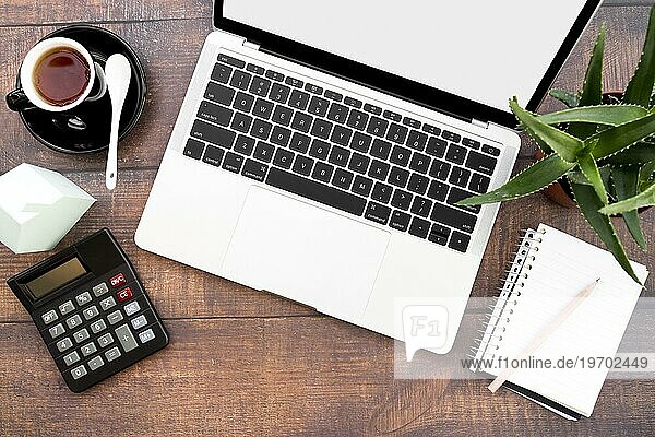 Open Laptop mit Kaffeetasse Spirale Notebook Taschenrechner Papier Haus Modell Aloe Vera Pflanzen Holztisch