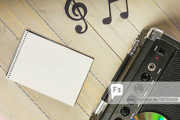 Draufsicht Spirale Notizblock musikalische Note Verstärker hölzernen Schreibtisch