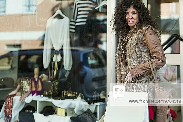Frau mit Einkaufstaschen beim Bummeln in einer Boutique
