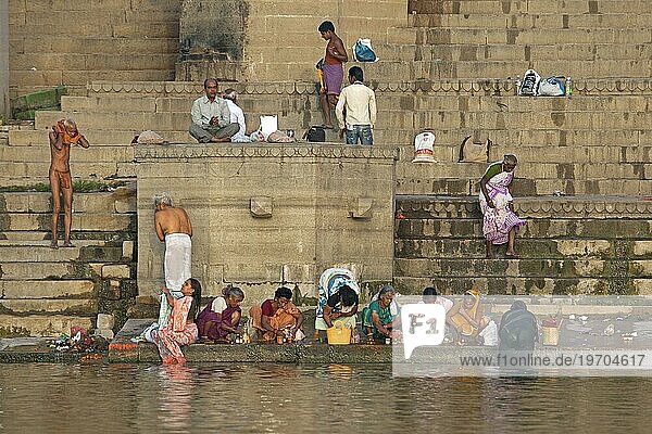Indische Menschen beim Baden und Beten im Fluss Ganges an einem Ghat in Varanasi,  Uttar Pradesh,  Indien,  Asien