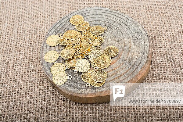 Viele gefälschte Goldmünzen befinden sich auf einem Stück Holz