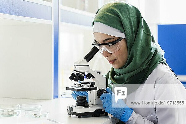 Seitenansicht Wissenschaftlerin mit Hidschab Mikroskop