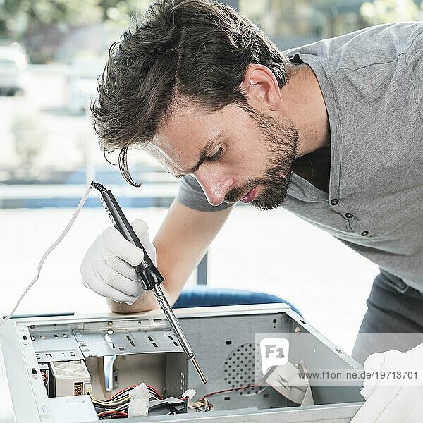 Seitenansicht männlicher Techniker  der eine Computer CPU Werkstatt repariert