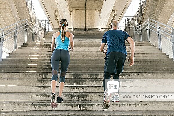 Rückansicht männlicher weiblicher Athlet joggend Treppenhaus