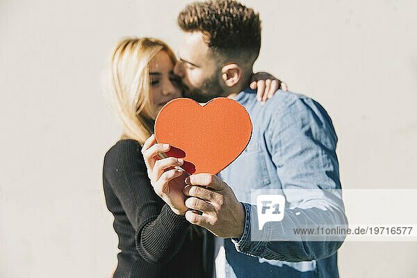 Verliebtes Paar posiert mit rotem Herz