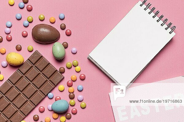 Blanko Spirale Notizblock Ostern Wort Ostereier mehrfarbigen Edelstein Süßigkeiten rosa Hintergrund