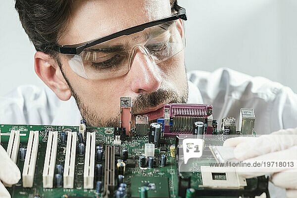 Männlicher Techniker beim Einsetzen eines Chip Computer Motherboards