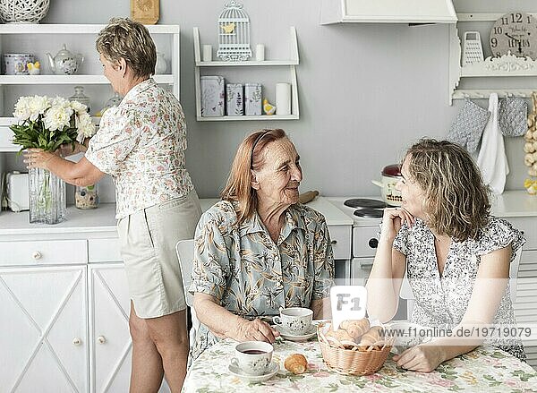 Oma und Enkelin unterhalten sich beim Frühstück miteinander