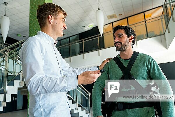 Mechanisches Exoskelett  Physiotherapeut im Gespräch mit einer behinderten Person mit Roboterskelett  Physiotherapie in einem modernen Krankenhaus  futuristische Physiotherapie