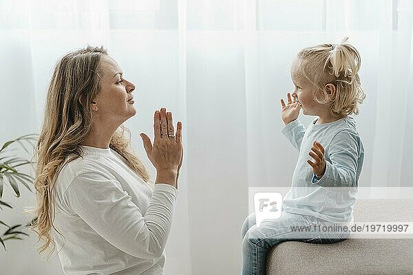 Seitenansicht Mutter betet mit ihrem Kind zu Hause
