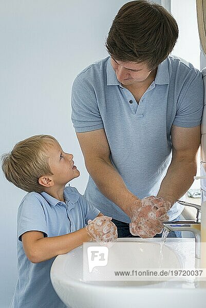 Nahaufnahme Vater lehrt Sohn  wie man die Hände wäscht